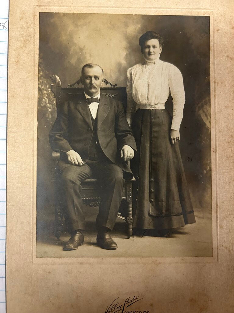 PHOTO CARD OF COUPLE W/ MAN SEATED